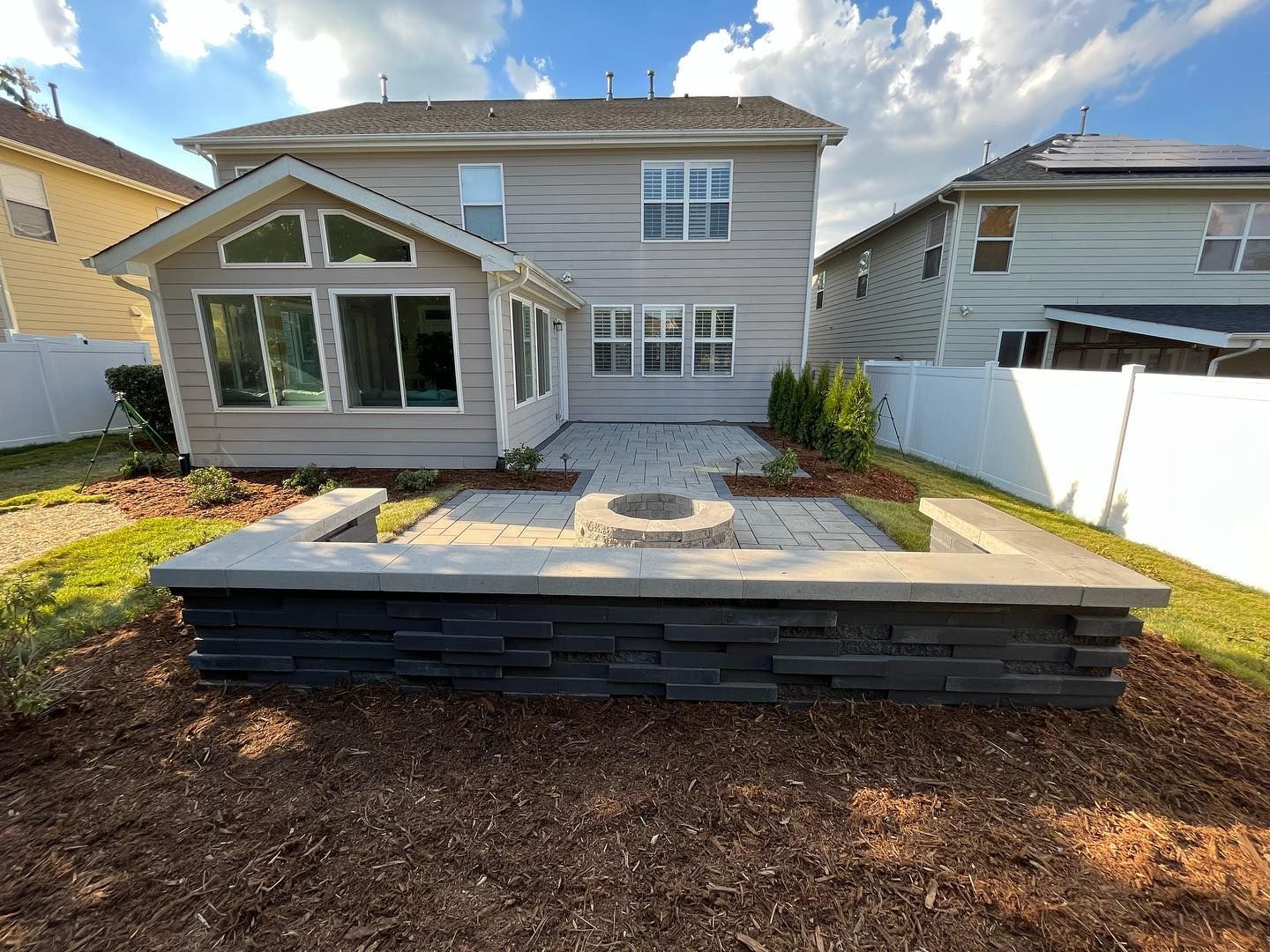 There is a fire pit in the backyard of a house.