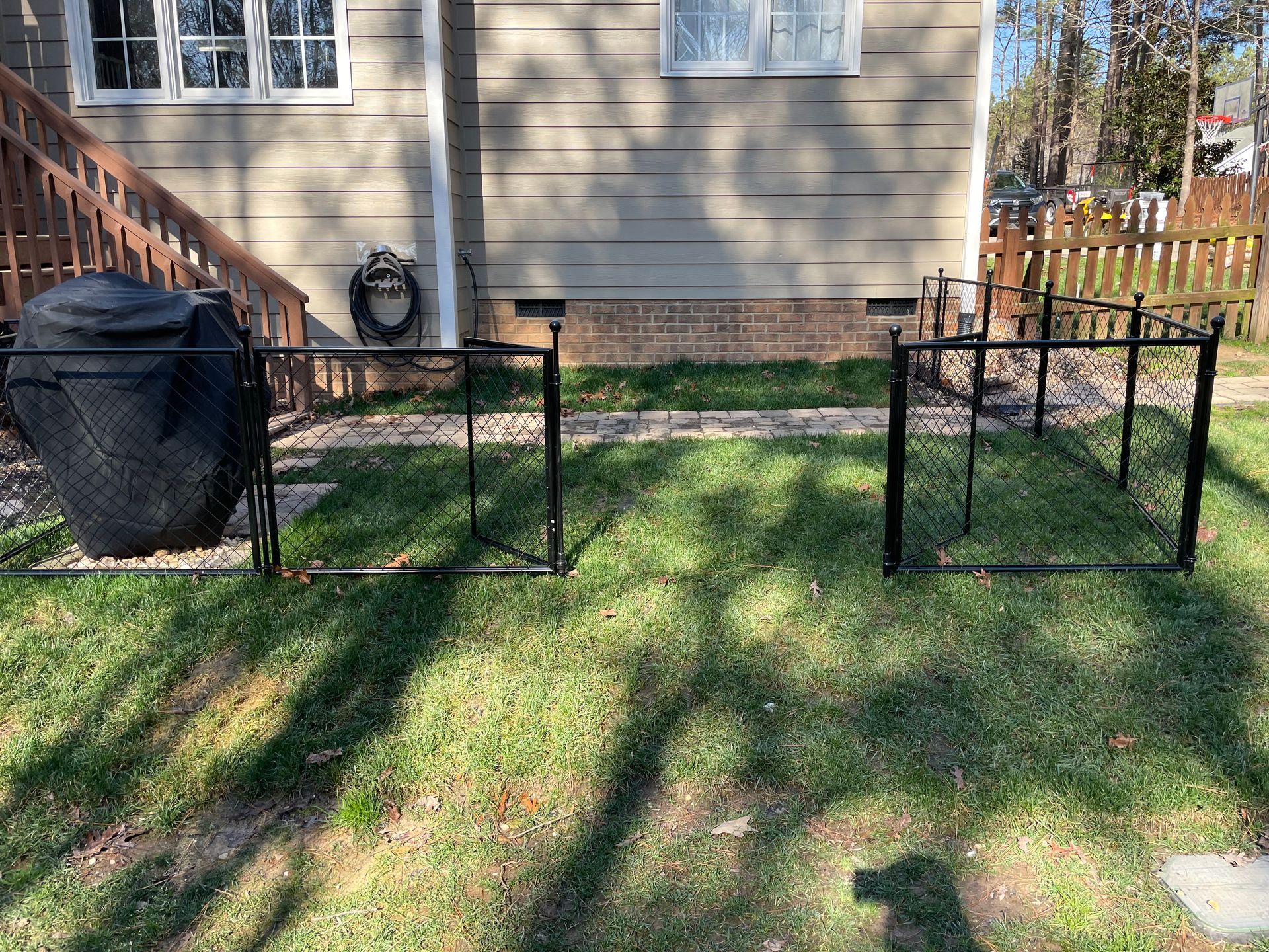 A fence is sitting in the grass in front of a house.