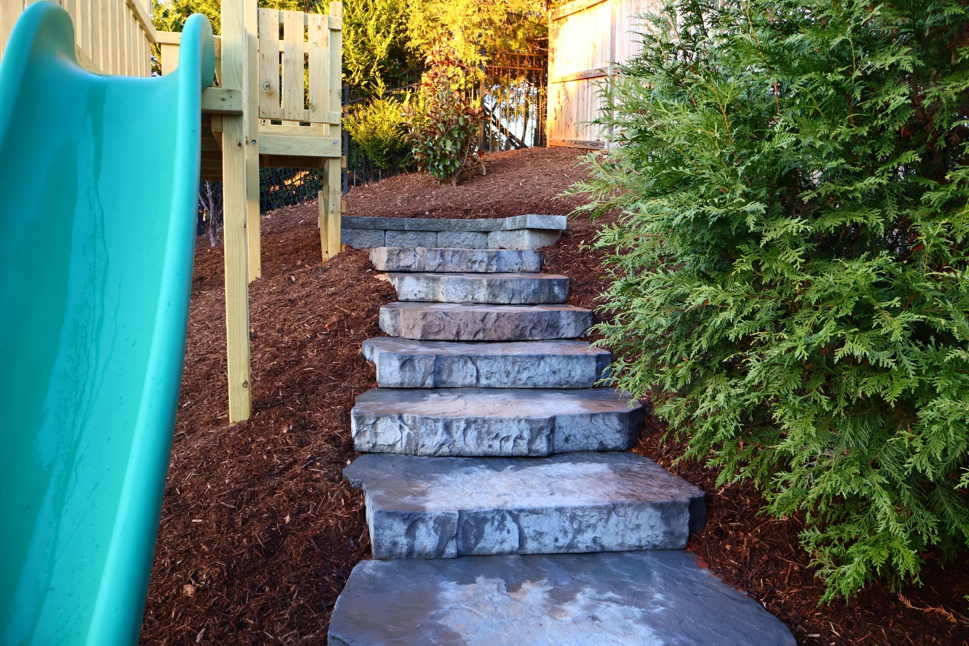 A set of stairs leading up to a slide in a backyard