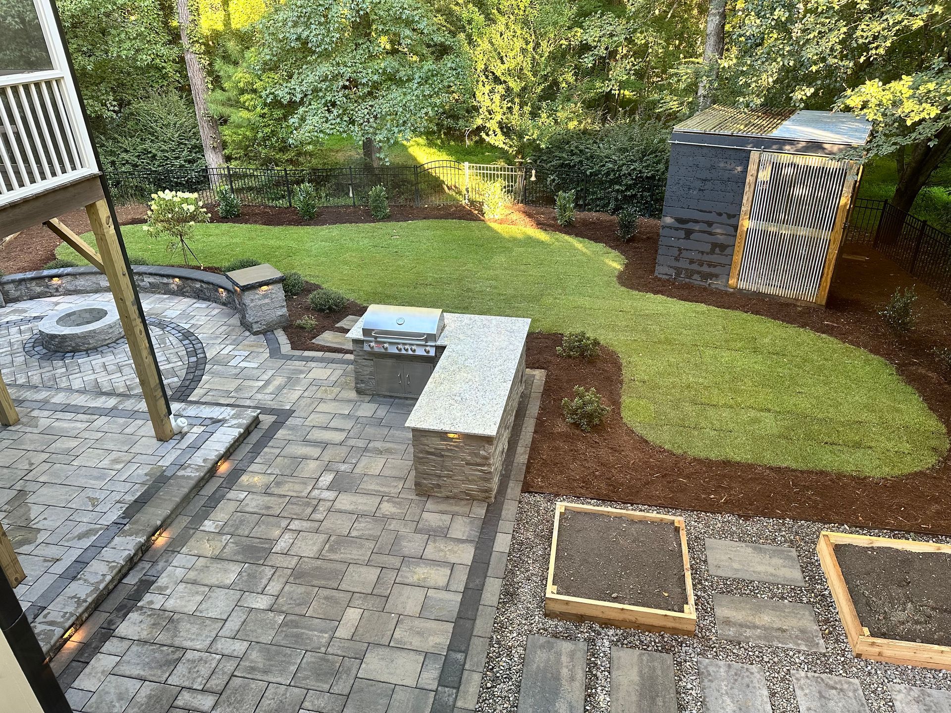 An aerial view of a backyard with a patio and a fire pit.