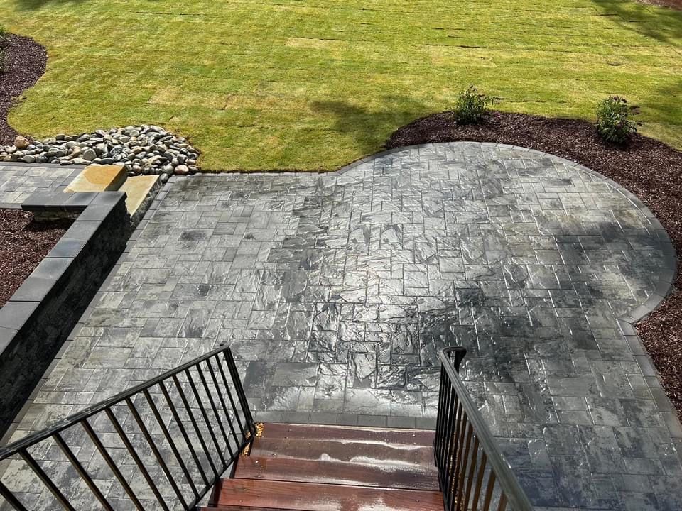 A staircase leading up to a patio with a lawn in the background.