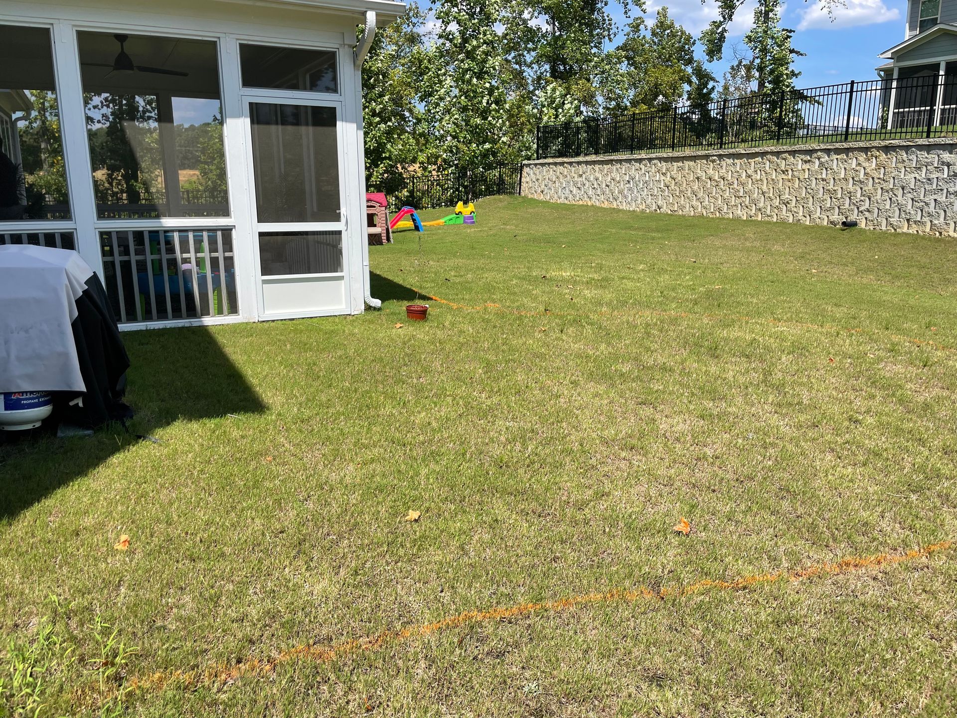 There is a screened in porch in the backyard of a house.