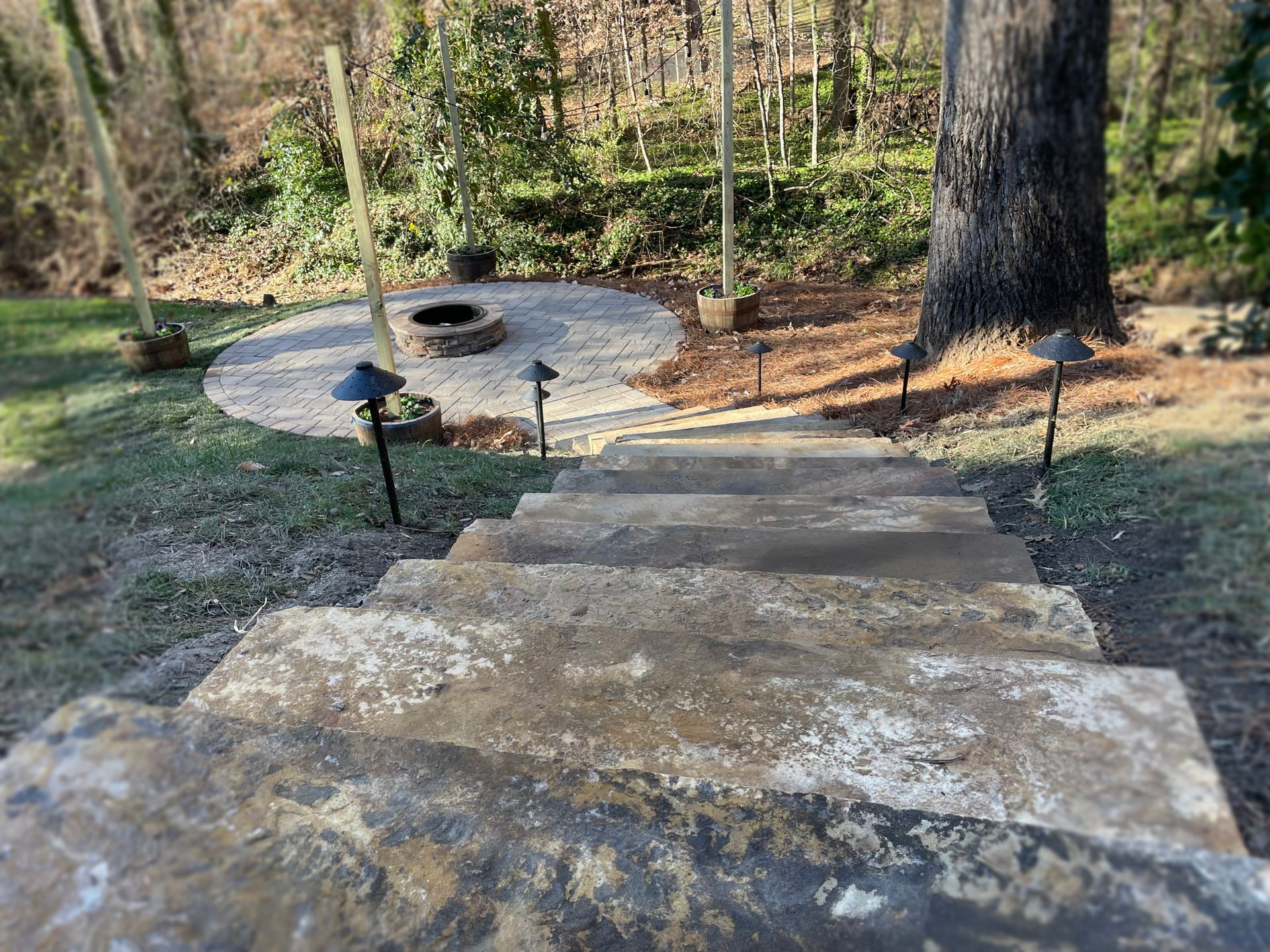 A set of stairs leading up to a fire pit in a backyard.