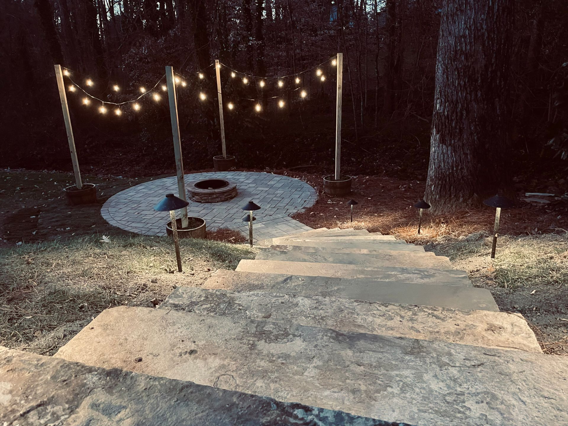 There is a fire pit in the middle of the yard with stairs leading up to it.