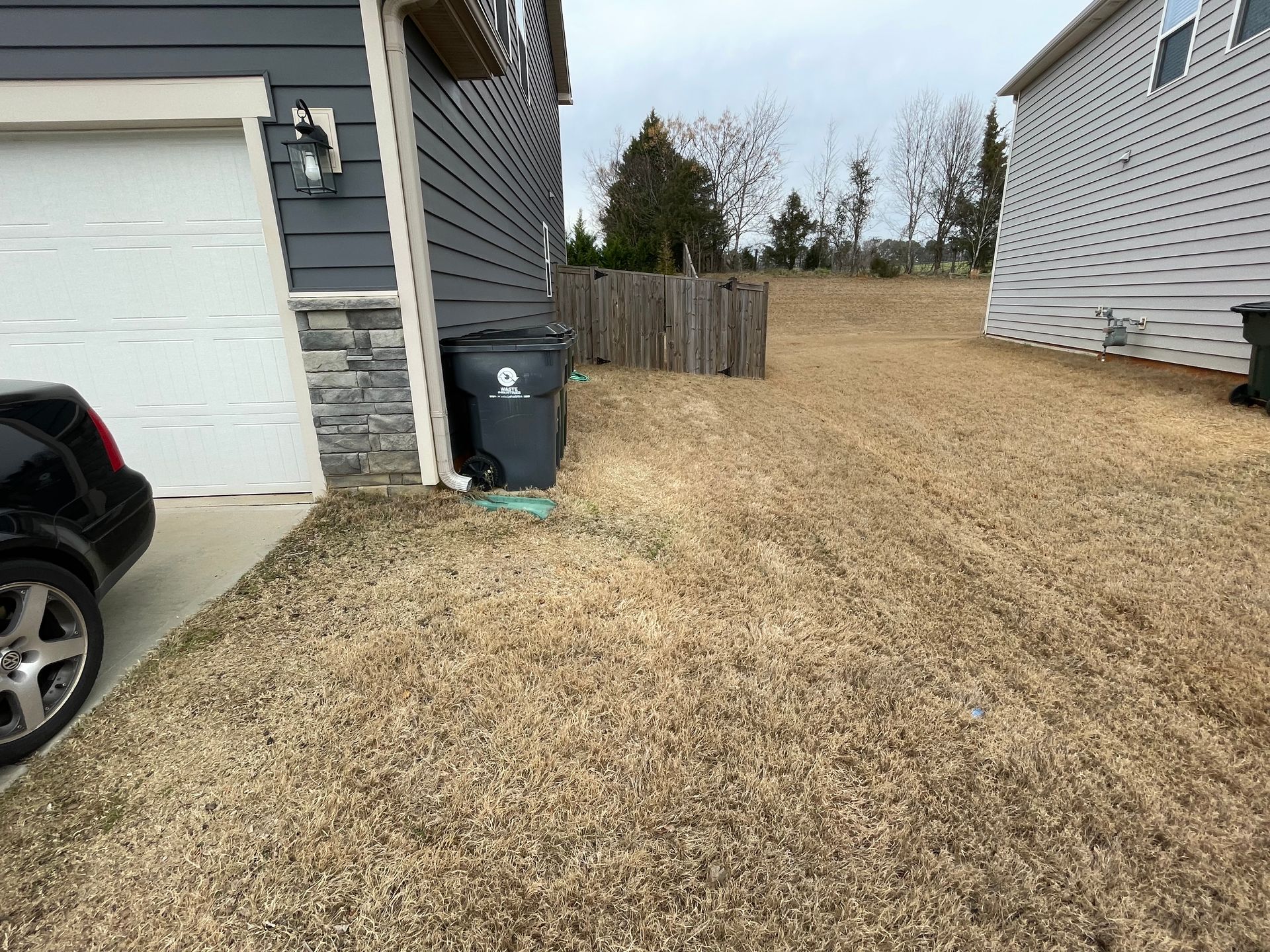 A car is parked in a driveway next to a house.