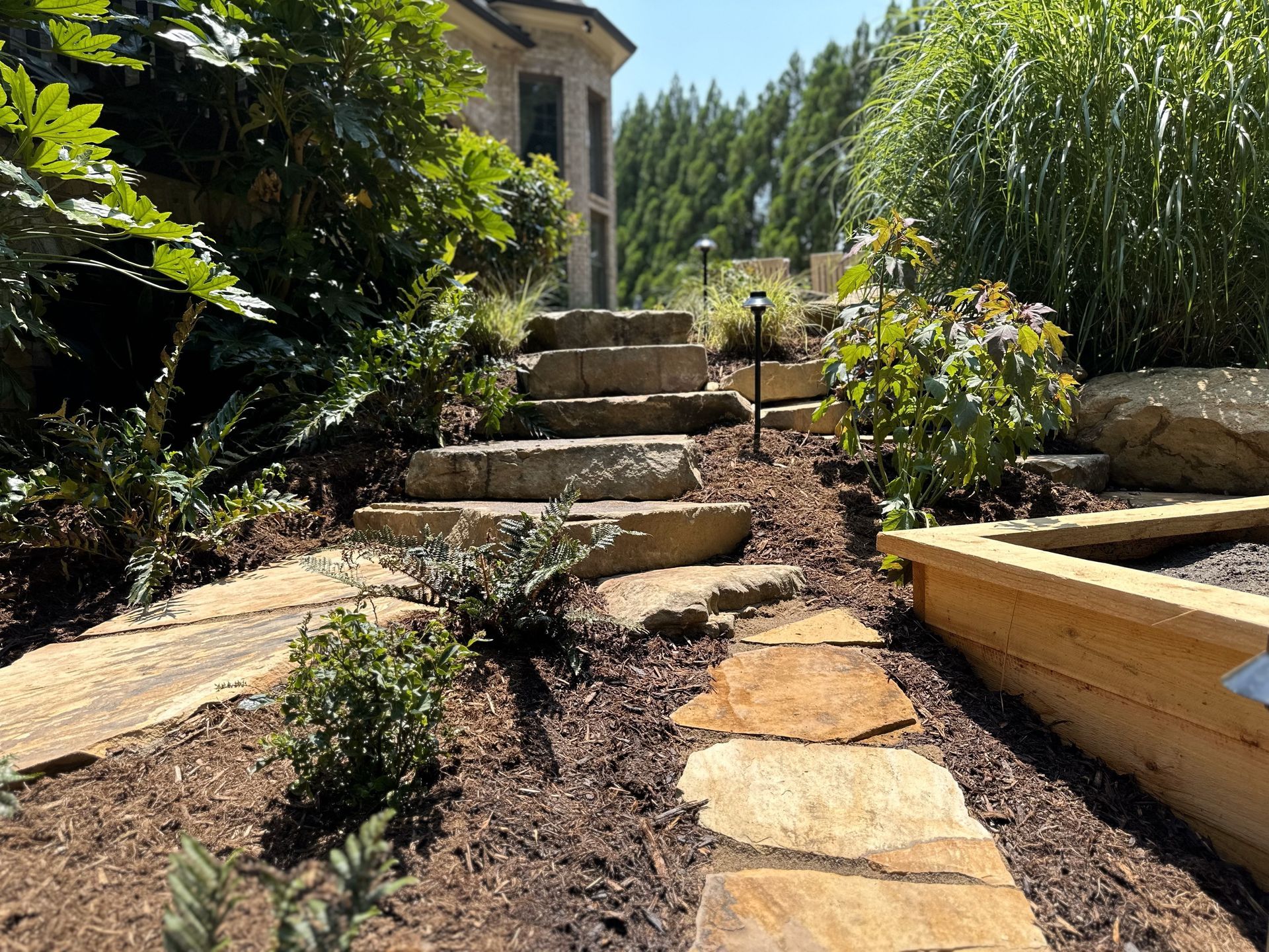 A stone walkway leading up to a house with stairs