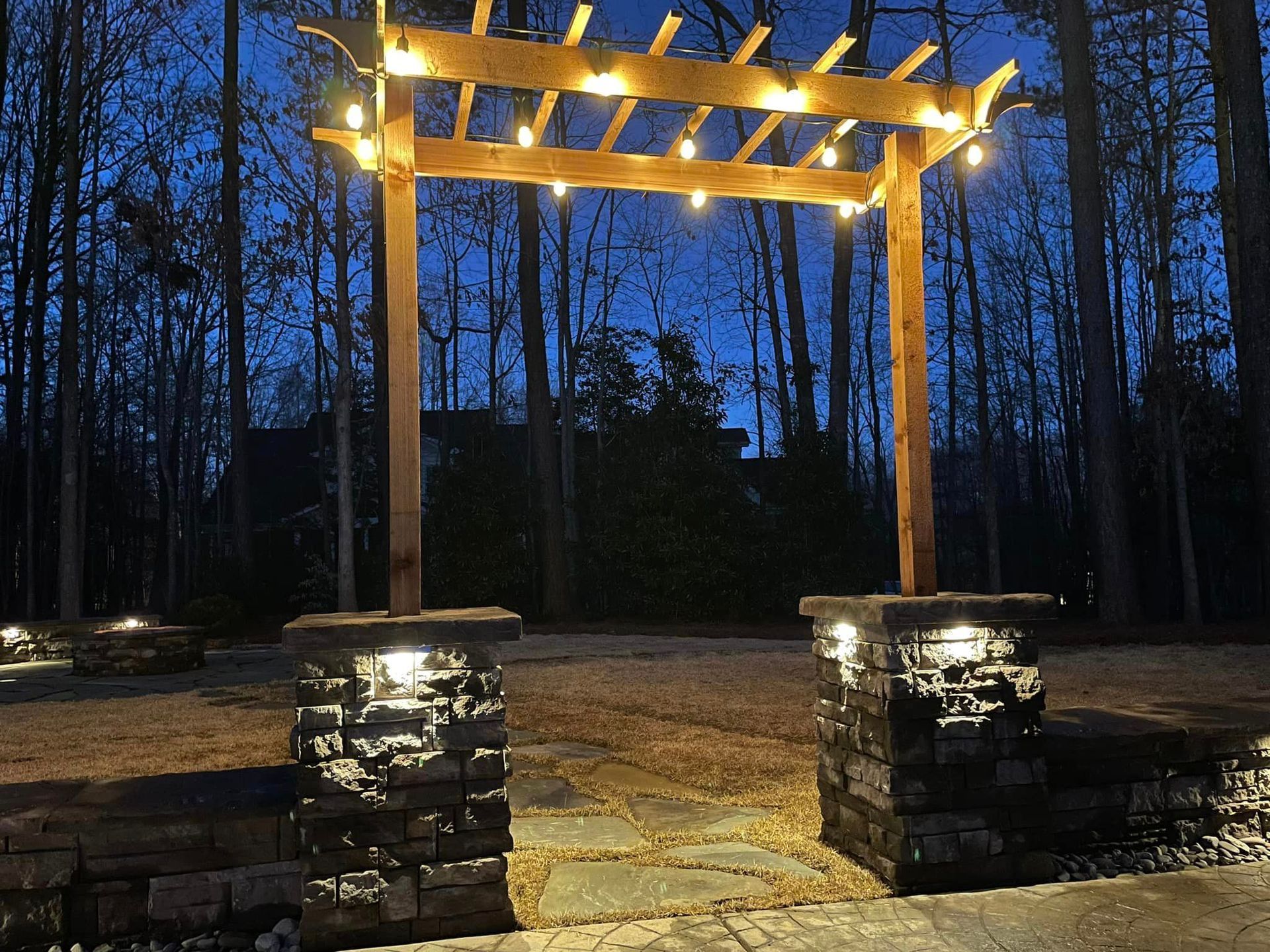 A pergola with lights hanging from it is lit up at night