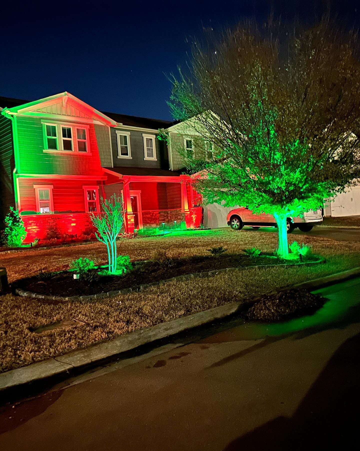 A house is decorated with red and green lights for christmas.