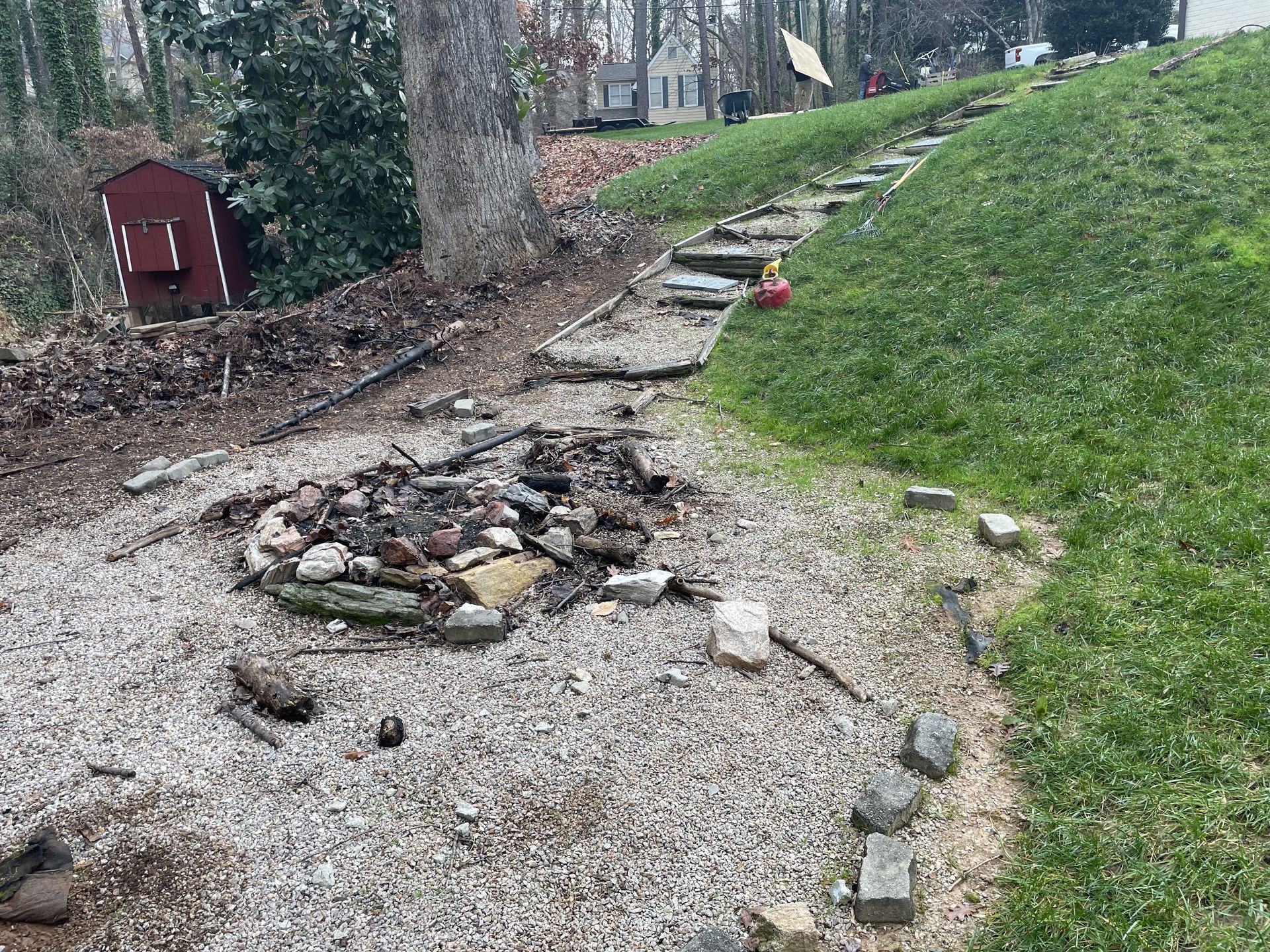 A gravel path with a fire pit in the middle of it.