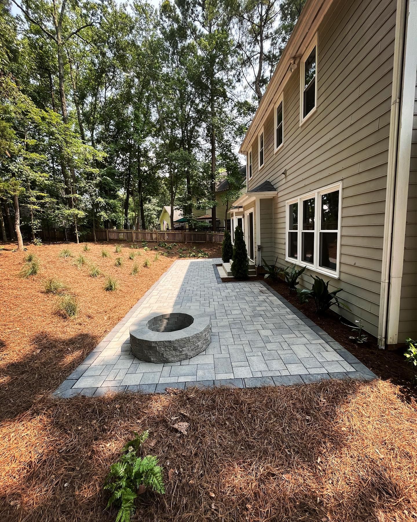 There is a fire pit in the backyard of a house.