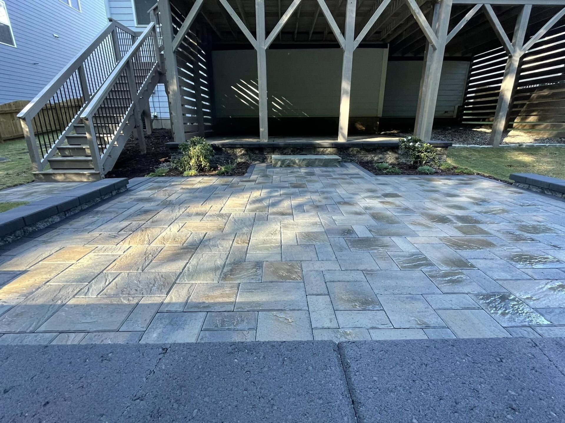 A brick walkway leading to a house with stairs.
