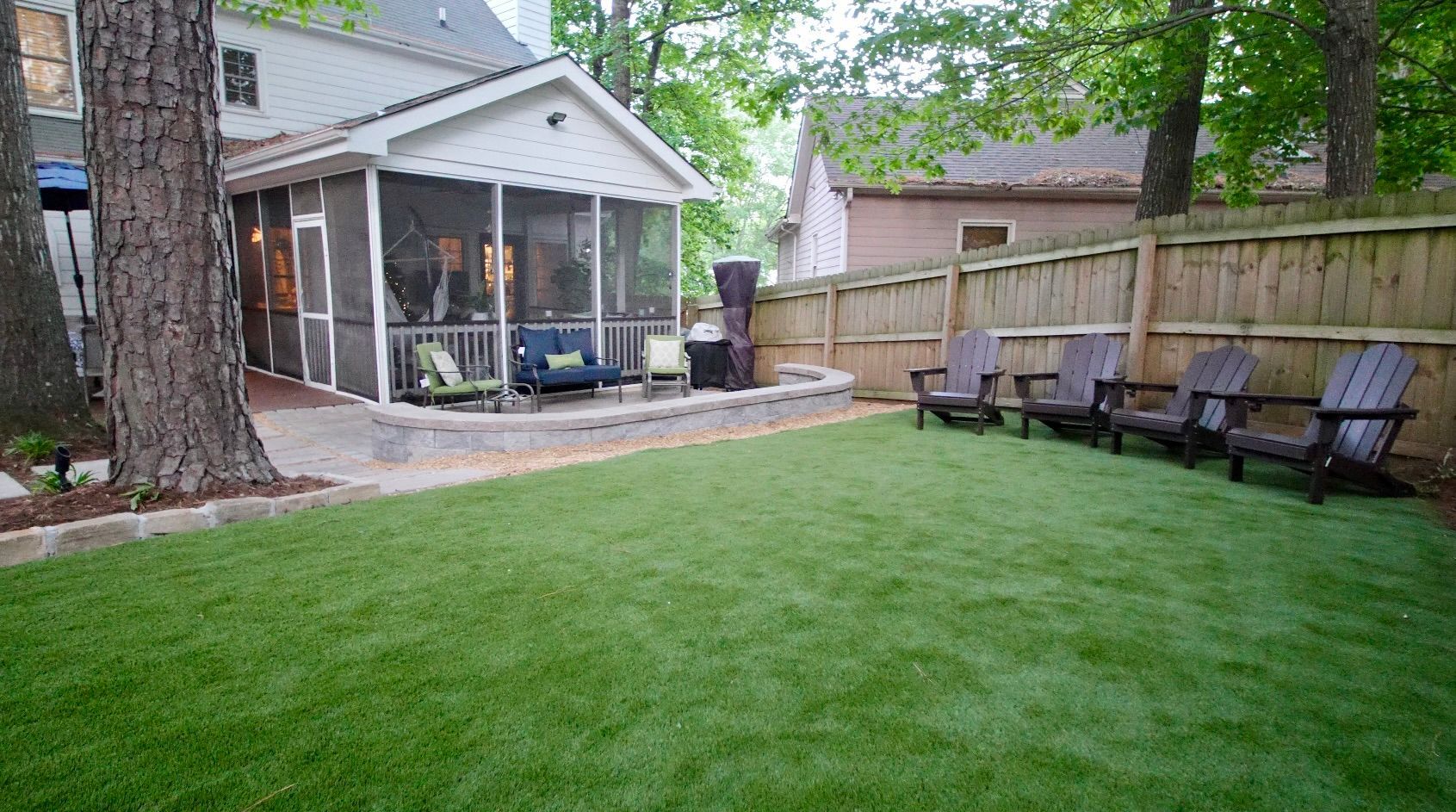 A lush green lawn with a wooden deck in the background.