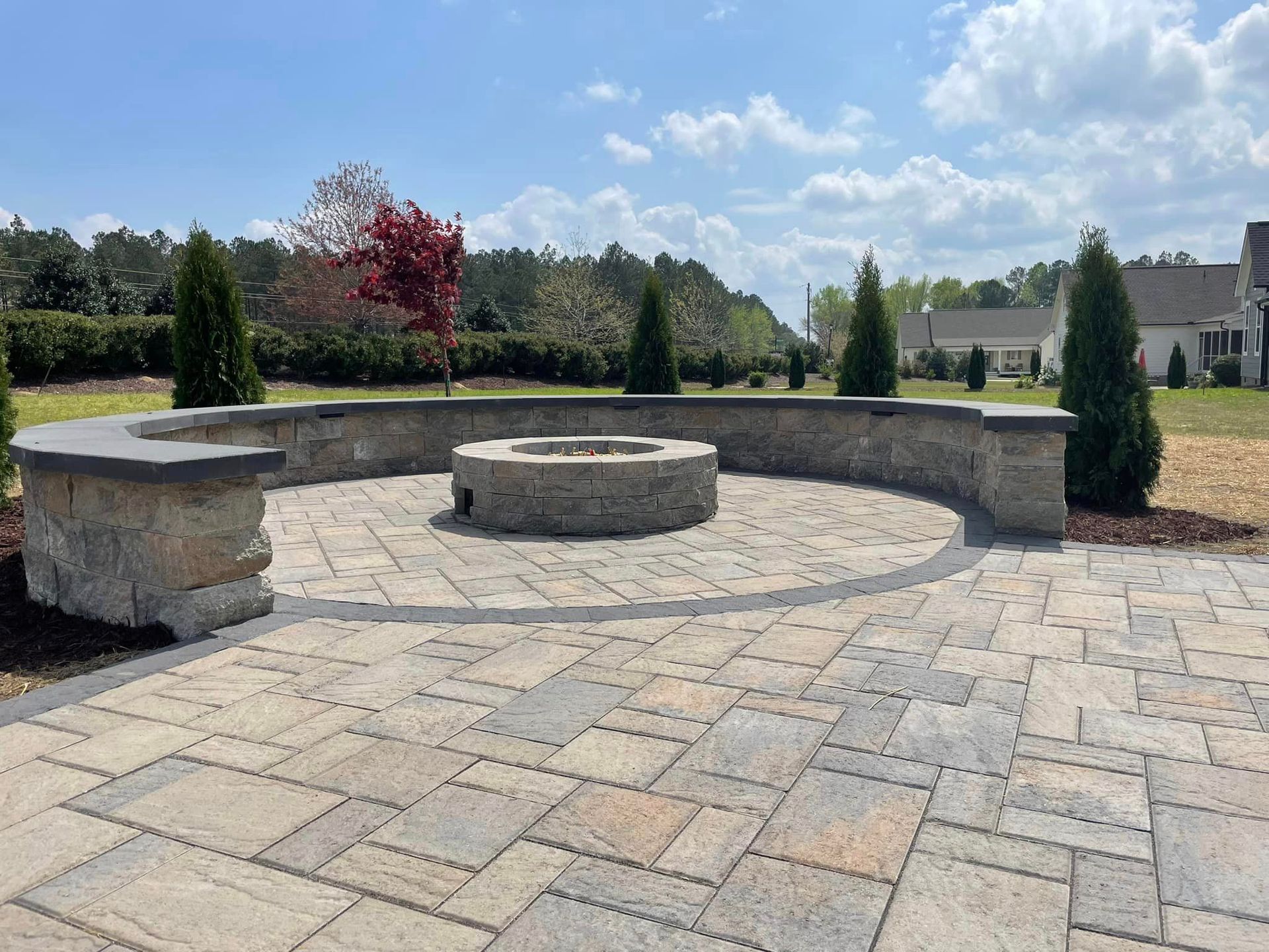 A brick patio with a fire pit in the middle