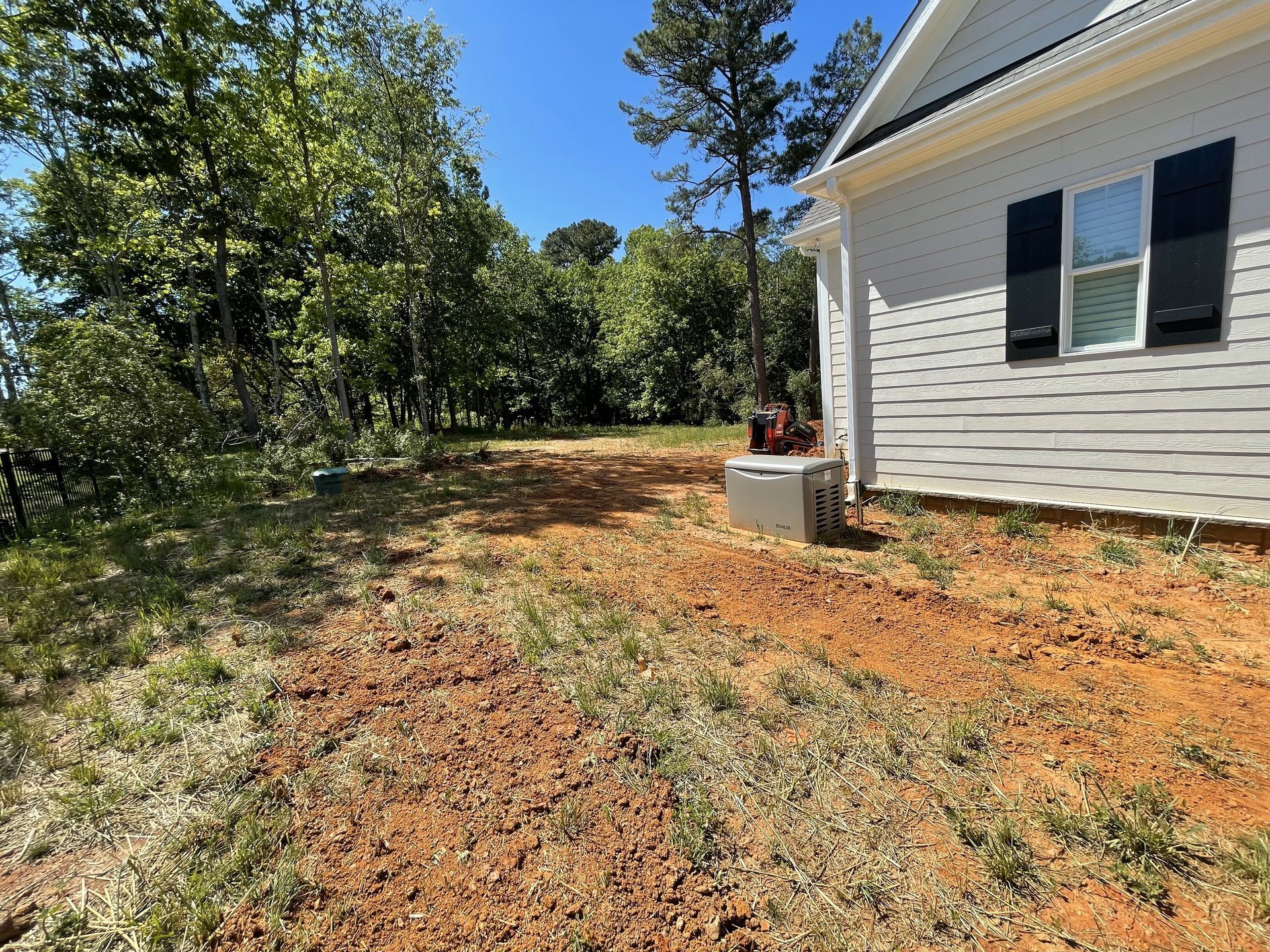 A white house with a lot of dirt in front of it.