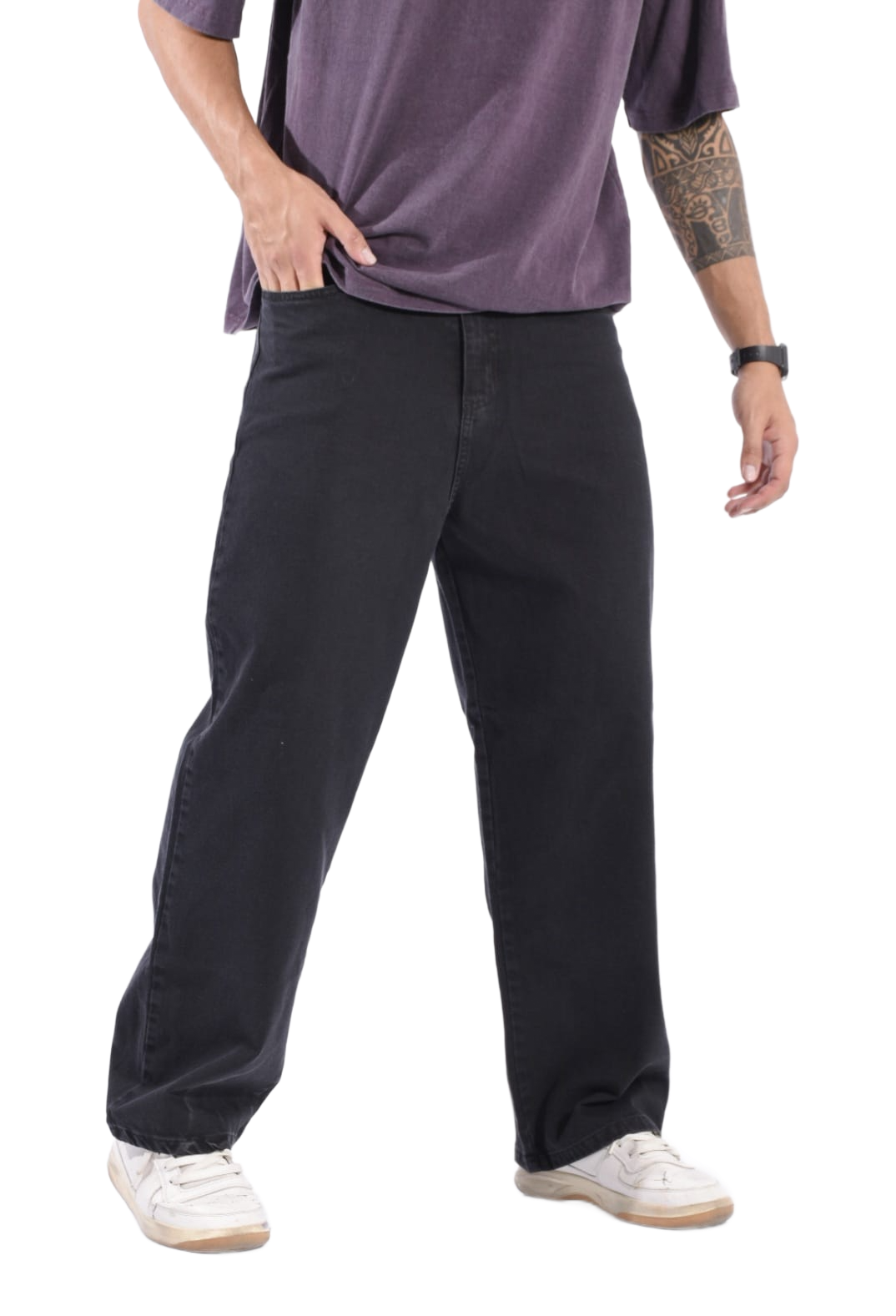Persona vestida con pantalones negros, camisa morada y zapatillas blancas de pie sobre un fondo blanco.