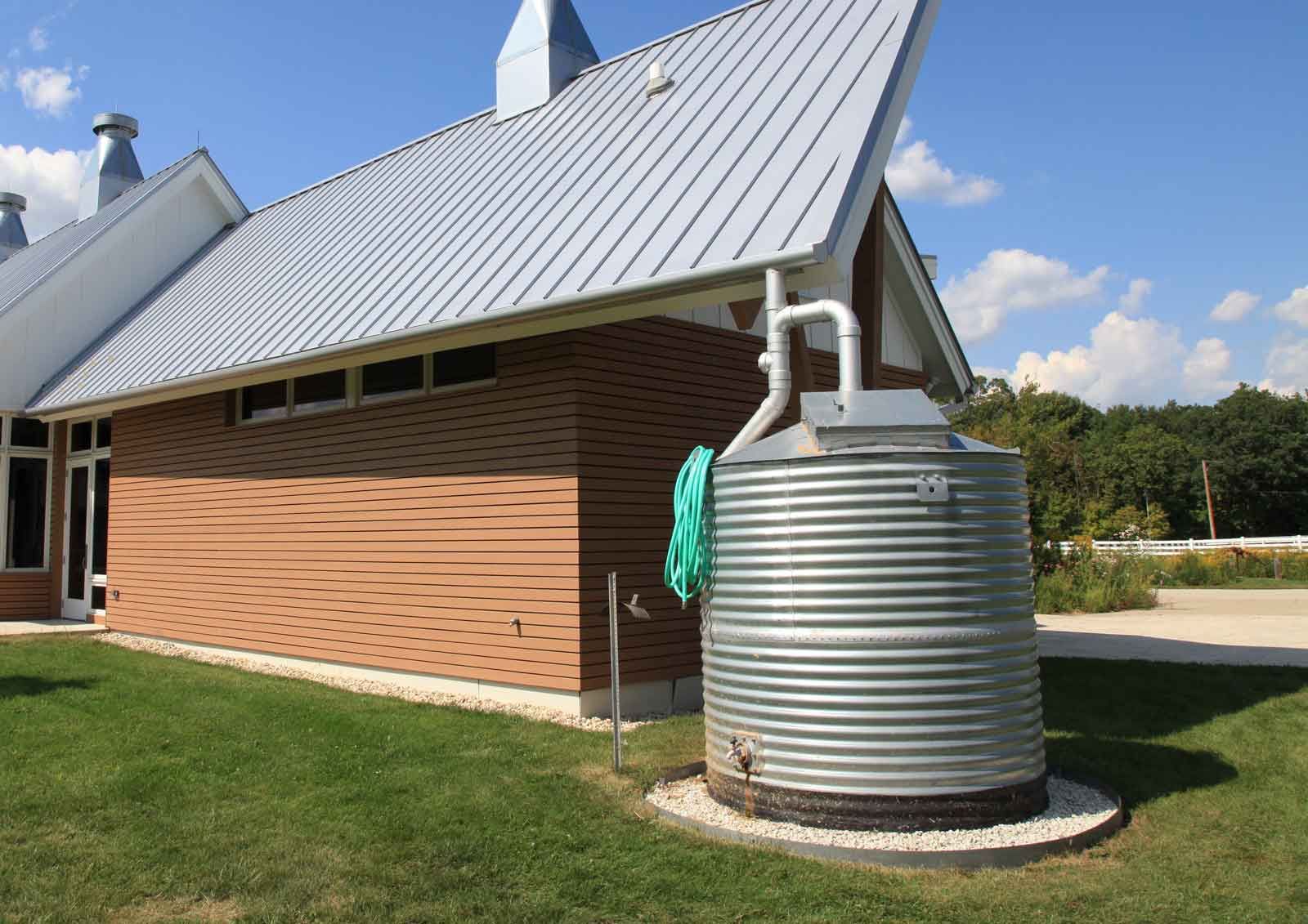 A large metal tank is sitting in front of a house.