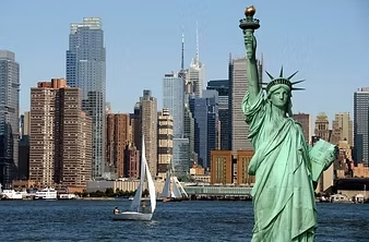 The statue of liberty is in front of a city skyline