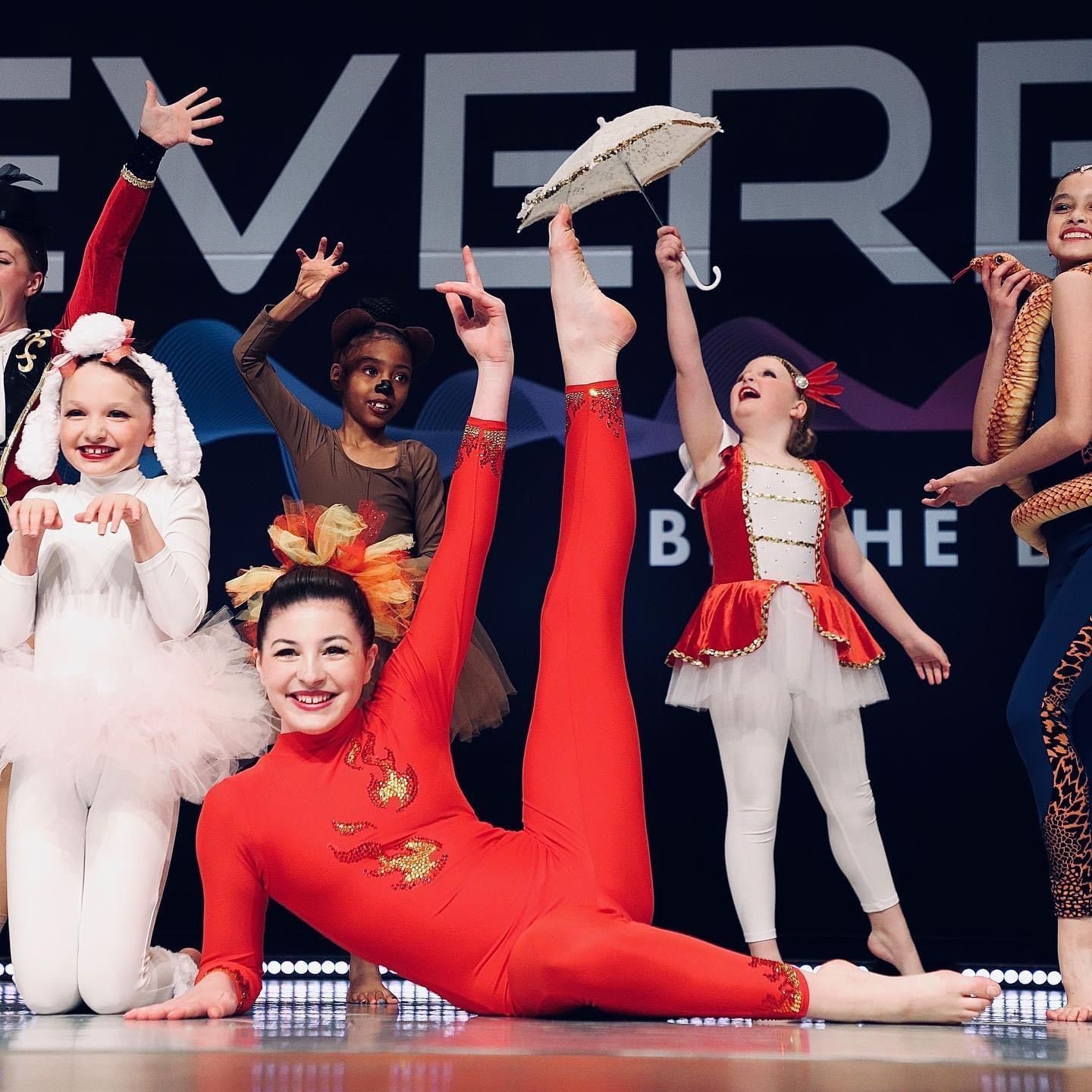 A group of young girls are posing for a picture in front of a sign that says everett