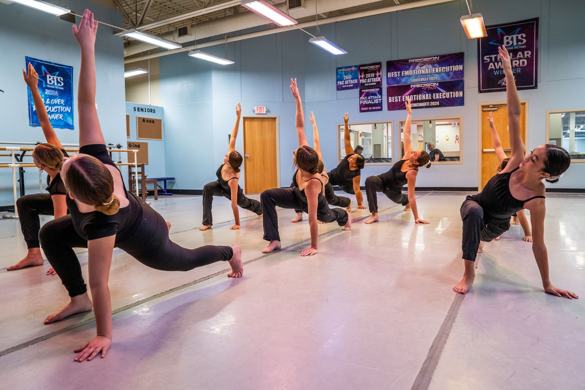A group of people are doing yoga exercises in a dance studio.