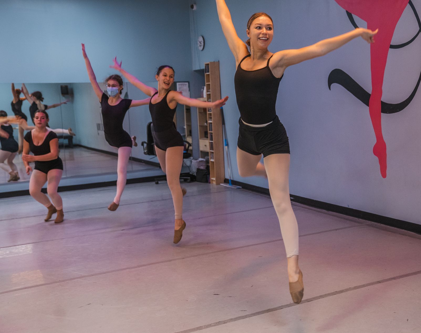 A group of young women are dancing in a dance studio.