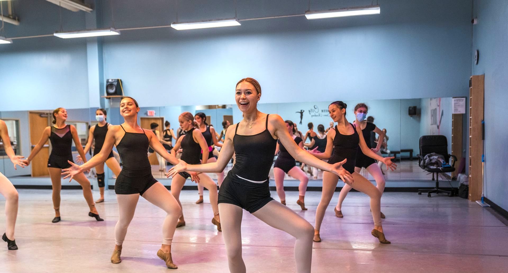 A group of young women are dancing in a dance studio.