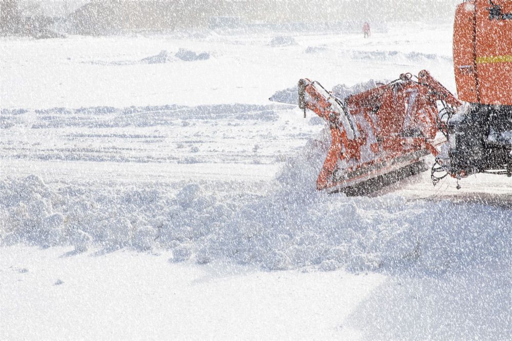 Une déneigeuse dégage une route de la neige pendant une tempête de neige.