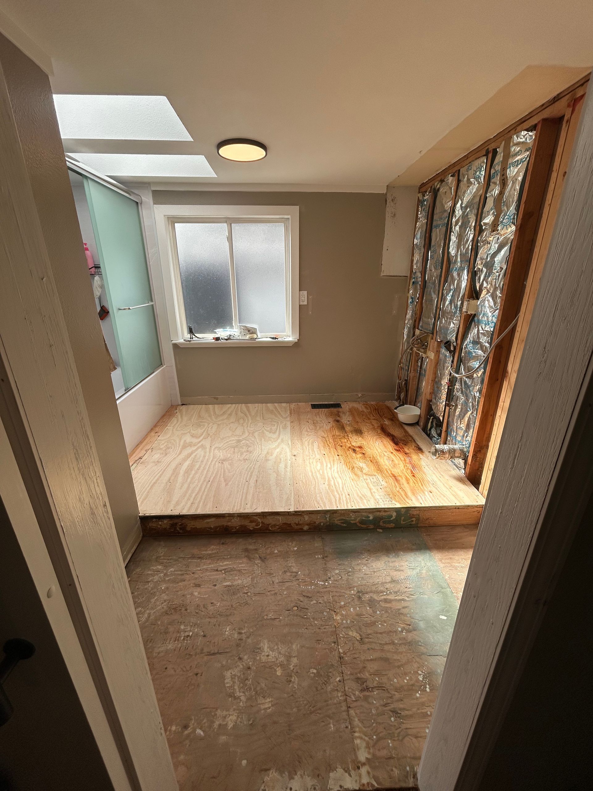 A room with a wooden floor and a window.