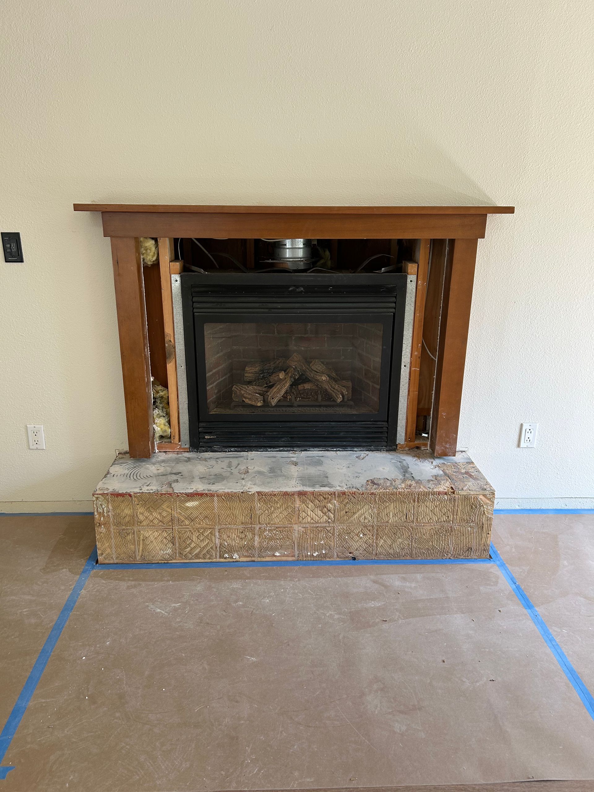 A fireplace is being remodeled in a living room.