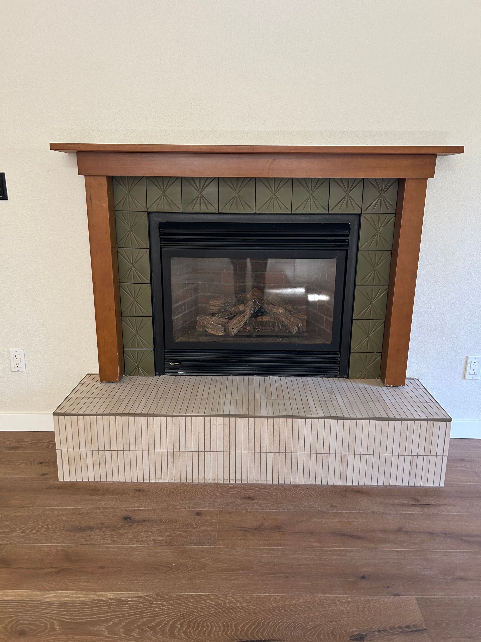 A fireplace in a living room with a wooden mantle