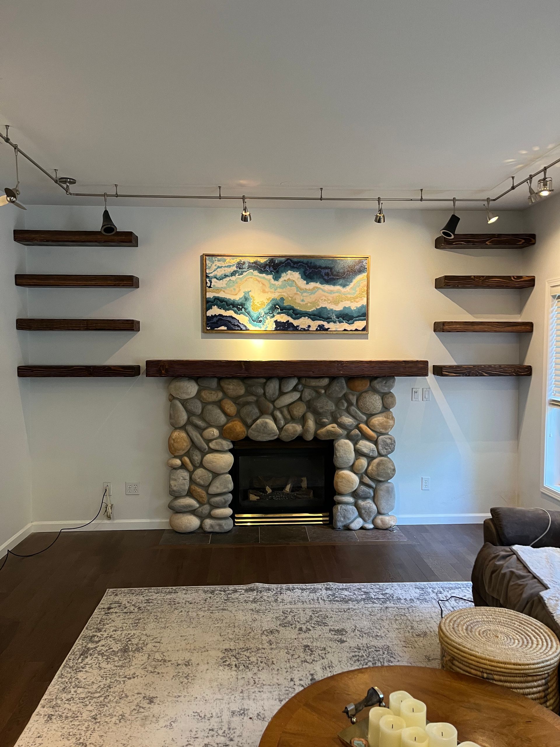 A living room with a fireplace and a painting on the wall.