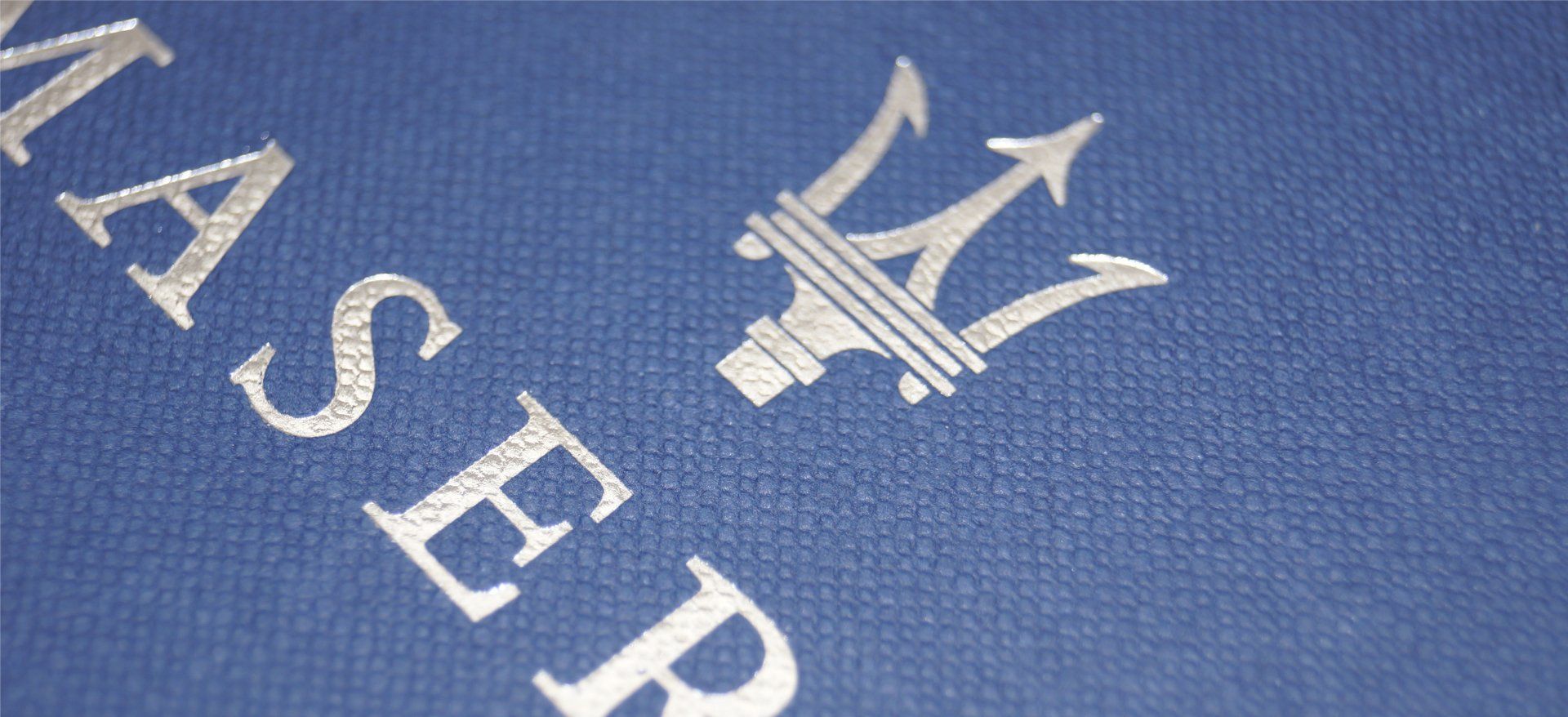 Scatola rivestita con particolare del marchio a caldo color argento su carta telata in pasta azzurra
