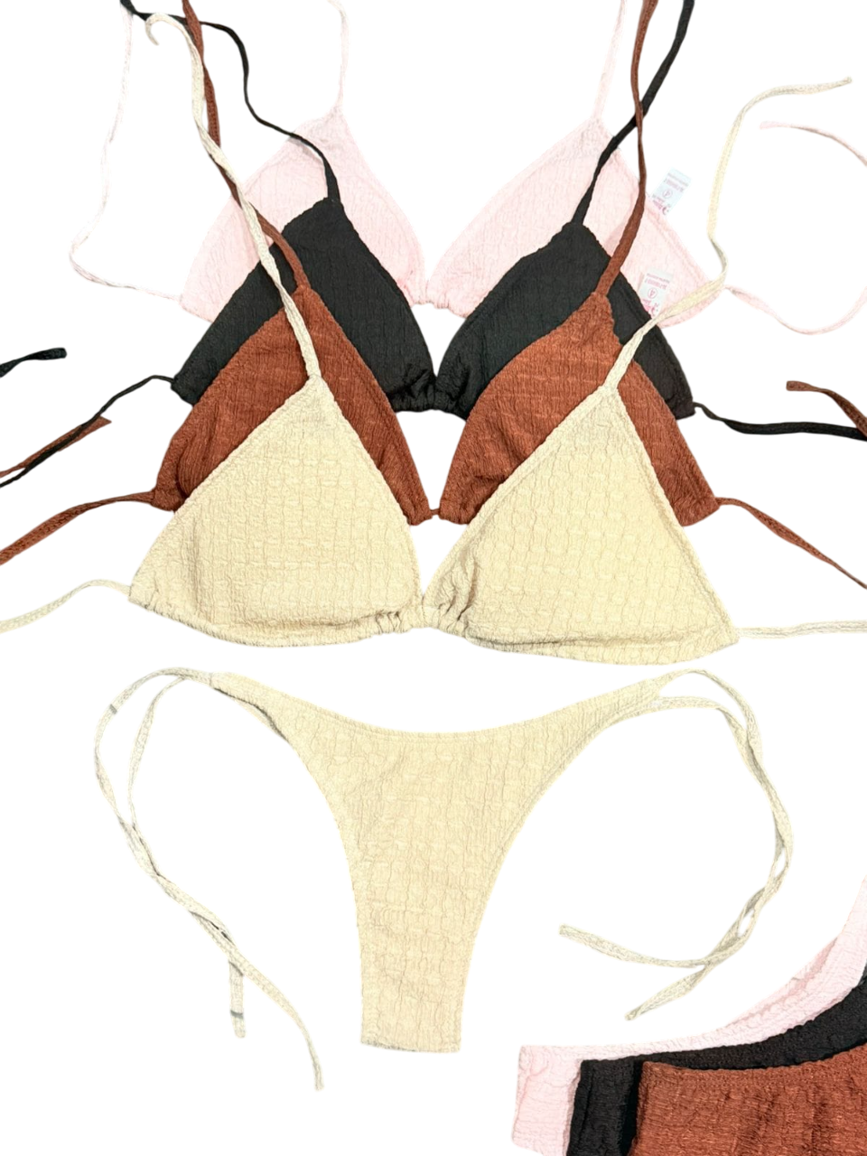 Varios colores, tops y braguitas de bikini triangulares, apilados para la venta.