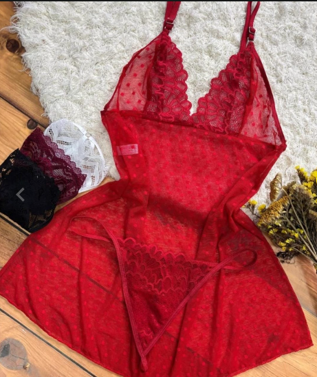 Conjunto de lencería roja con detalles de encaje sobre alfombra de piel blanca, superficie de madera y bragas surtidas.