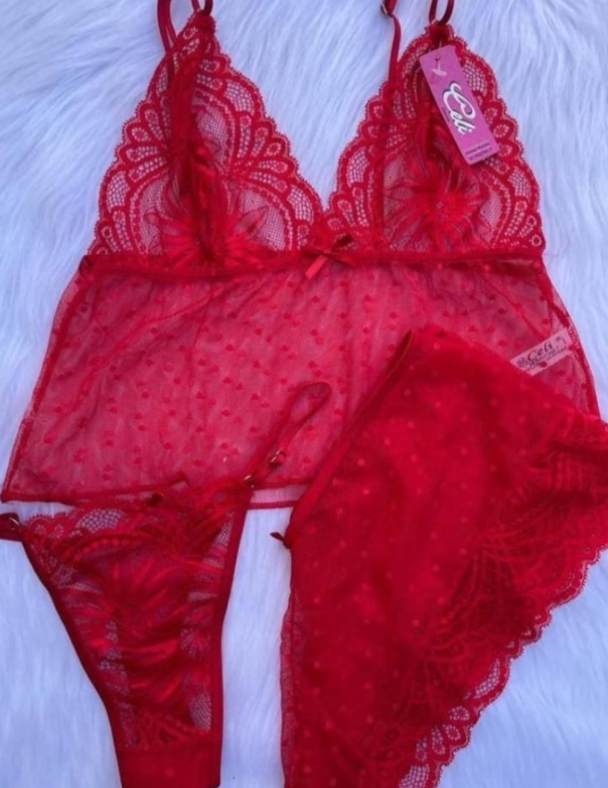 Mujer en lencería negra y sombrero, sonriendo, con las manos en las caderas.