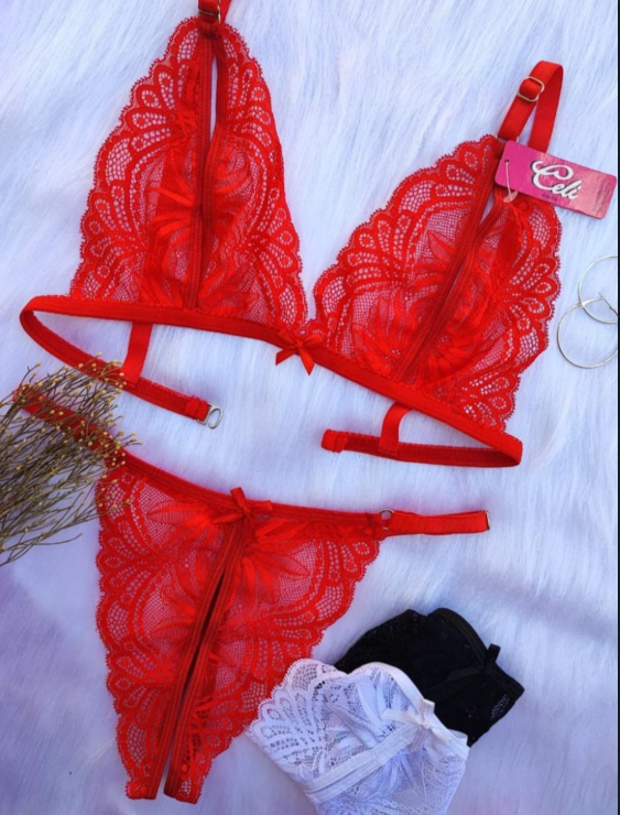 Conjunto de lencería de encaje rojo con bralette y tanga, expuesto sobre una superficie blanca esponjosa.