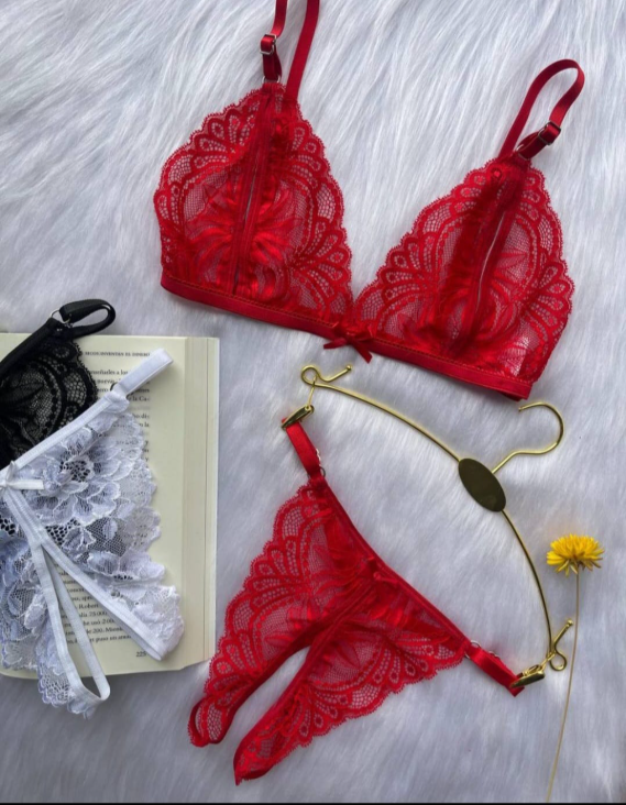 Conjunto de lencería de encaje rojo con bralette y tanga, expuesto sobre una superficie blanca esponjosa.