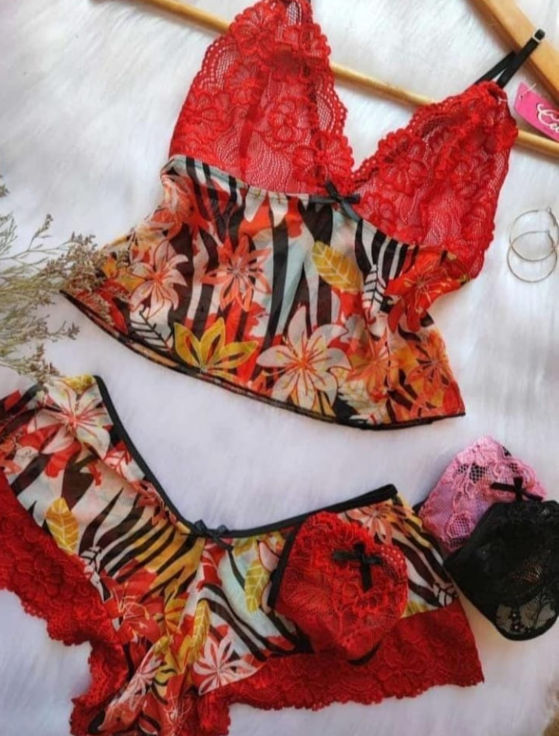 Conjunto de lencería de color rojo con estampado floral y detalles de encaje sobre fondo blanco, que incluye camisola y pantalones cortos.
