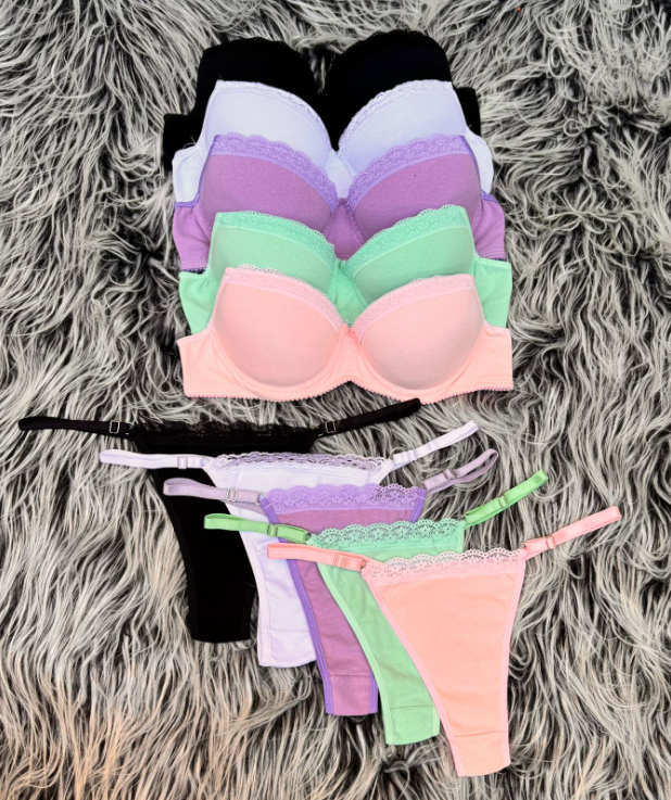 Pila de sujetadores coloridos y tangas a juego sobre una superficie esponjosa y texturizada.