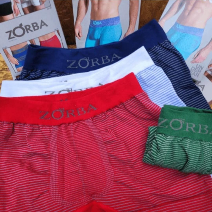 Primer plano de calzoncillos bóxer Zorba en rojo, blanco, azul y verde, con el logotipo y el embalaje visibles.