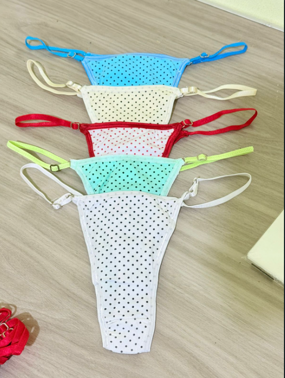 Cinco tangas coloridas y perforadas sobre una superficie de madera.