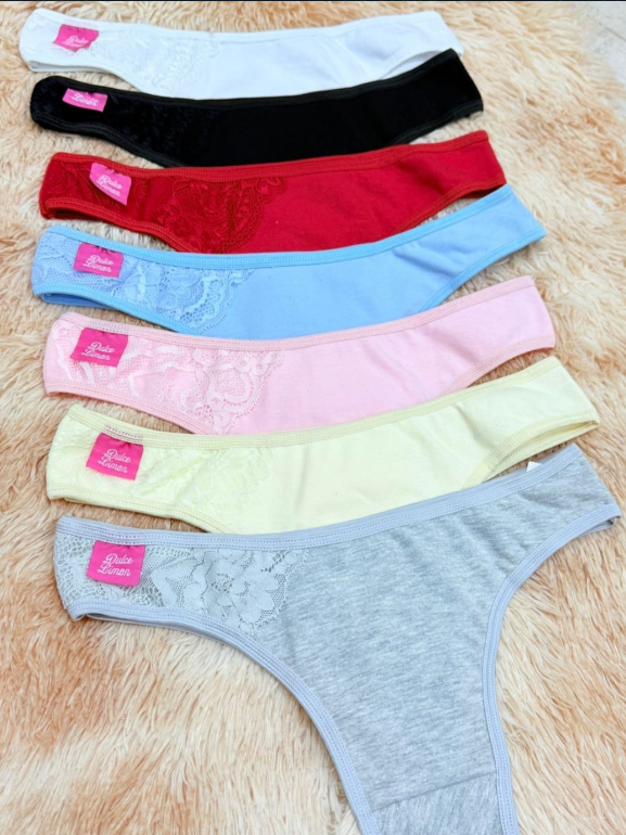 Siete tangas de colores dispuestas sobre una superficie difusa; los colores incluyen blanco, negro, rojo, azul, rosa, amarillo y gris.