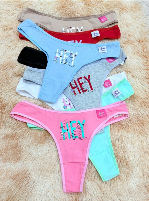 Pila de ropa interior tipo tanga de colores sobre una superficie texturizada; cada pieza con gráficos y etiquetas de marca.