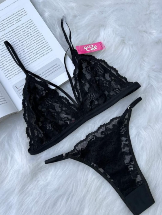 Conjunto de lencería de encaje blanco sobre una superficie similar a una piel blanca con un libro de fondo.