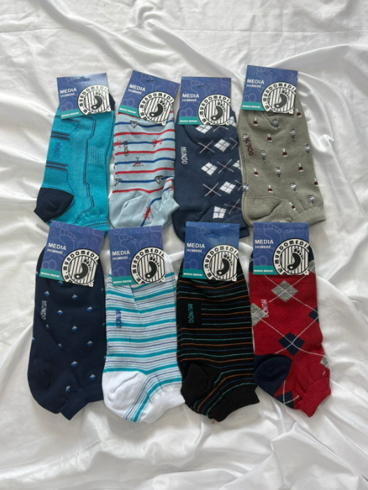 Ocho pares de calcetines estampados de colores sobre una superficie blanca, cada uno con una etiqueta de marca.