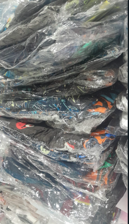 Cuatro calzoncillos bóxer para hombre en envase de plástico. Los estampados incluyen negro liso, lunares, pelotas de baloncesto y el logotipo repetido de la marca.