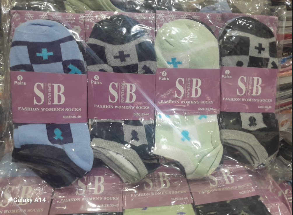 Cuatro paquetes de calcetines tobilleros para mujer. Cada uno tiene un color y estampado diferente: azul, azul oscuro, verde y gris.