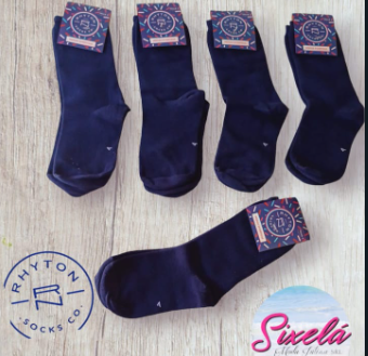 Cinco calcetines de color azul marino con etiquetas adheridas sobre superficie de madera.