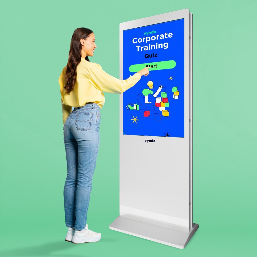 A woman stands next to a large screen labeled "Company training".