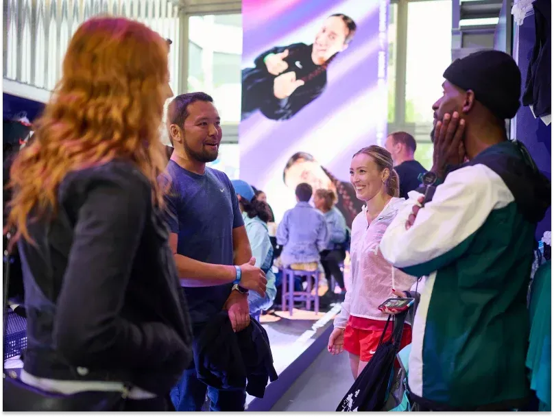 A group of people stand in a room and talk to each other