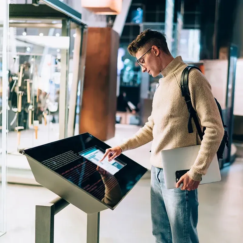 A man uses a touchscreen in a museum.